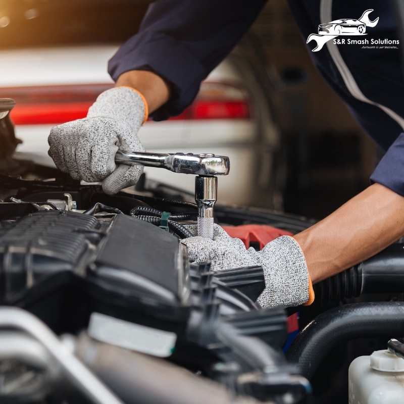 A mechanic in Abbotsbury diligently repairs a car engine, showcasing expertise in automotive services and maintenance.